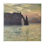 The Cliff Etretat, Sunset by Claude Monet Tile<br><div class="desc">The Cliff, Etretat, Sunset (1883) by Claude Monet is a vintage impressionist fine art nautical painting. The sun is low in the sky over the ocean. A maritime seascape featuring a rocky outcrop near the shore at Etretat, France. About the artist: Claude Monet (1840-1926) was a founder of the French...</div>