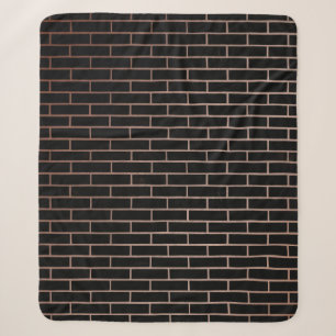 The dark black brick wall has a rough surface as a sherpa blanket