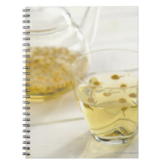 The herb tea which a glass teapot and a cup spiral notebook