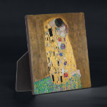 The Kiss by Gustav Klimt Plaque<br><div class="desc">The Kiss by Gustav Klimt The Kiss is an oil-on-canvas painting with added gold leaf, silver and platinum. by the Austrian Symbolist painter Gustav Klimt. It was painted at some point in 1907 and 1908, during the height of what scholars call his "Golden Period". Featuring shimmering gold tones, stylized forms,...</div>