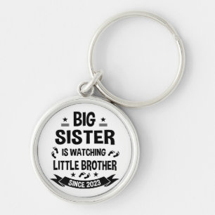 The little sister takes care of the big brother in key ring