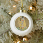 The Lovers Kissing Embrace by Gustav Klimt Ceramic Ball Christmas Ornament<br><div class="desc">Sunlight glints off the swirling golden embrace that surrounds the lovers in Gustav Klimt's masterpiece, The Kiss. The scene is a paradox of intimacy and isolation. The couple stands on a precipice, a field of colourful flowers at their feet, yet they are oblivious to the world around them. Their gazes...</div>