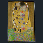 The Lovers Kissing Embrace by Gustav Klimt Medium Gift Bag<br><div class="desc">Sunlight glints off the swirling golden embrace that surrounds the lovers in Gustav Klimt's masterpiece, The Kiss. The scene is a paradox of intimacy and isolation. The couple stands on a precipice, a field of colourful flowers at their feet, yet they are oblivious to the world around them. Their gazes...</div>