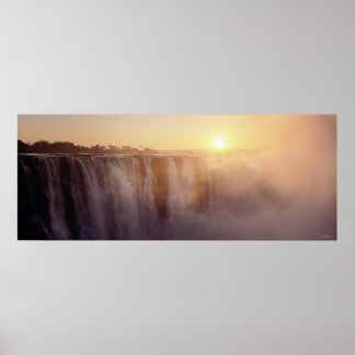 The sun rises behind the spray from Victoria Poster