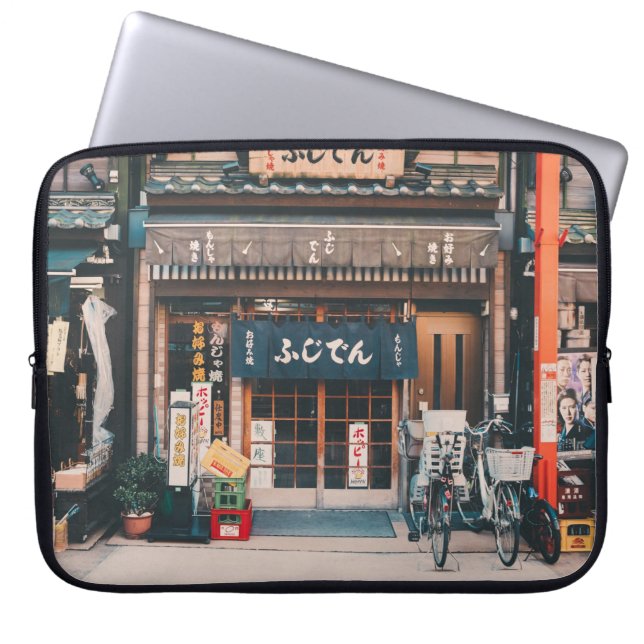 THREE BICYCLES PARKED IN FRONT OF BUILDING LAPTOP SLEEVE (Front)