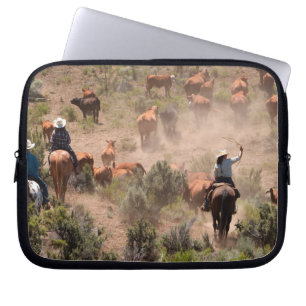 Three cowboys and cowgirls driving cattle laptop sleeve