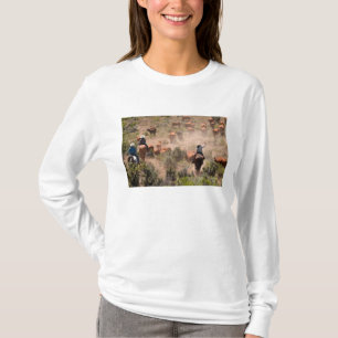 Three cowboys and cowgirls driving cattle T-Shirt