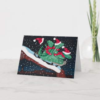 Three sledding dinosaurs holiday card