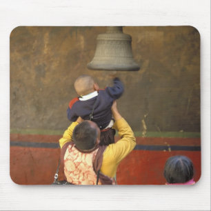 Tibetan Buddhist monk lifting a boy to ring a Mouse Pad