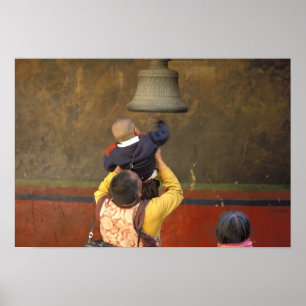 Tibetan Buddhist monk lifting a boy to ring a Poster