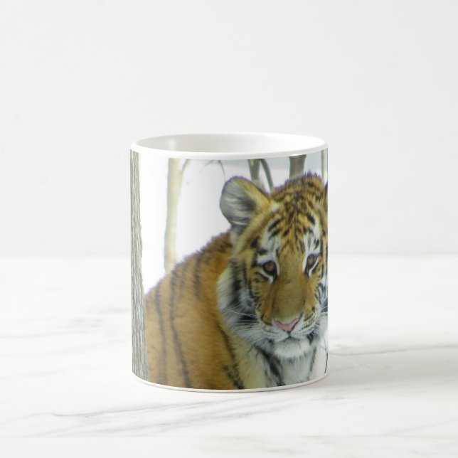 Tiger Cub In Snow Peeking Around Tree Coffee Mug (Center)