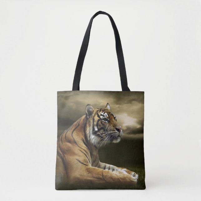 Tiger looking and sitting under dramatic sky tote bag (Front)
