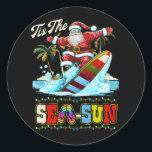 Tis The Sea Sun Santa Beach Summer Christmas In Ju Classic Round Sticker<br><div class="desc">Xmas Awesome Family Party. Fourth of July celebrating Baby. Christmas at the beach or lake pool resort camping. relax for the mid year review from santa claus. presents under the mistletoe, Christmas in Summer, Beach Party, Cruise Christmas in July. Awesome Xmas tee or X-mas present for Santa lover. Cool for...</div>