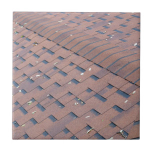 Top view of brown roof shingles with a few autumn tile