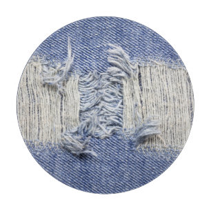 Torn blue denim: jeans texture. cutting board