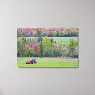 Tractor with hay bale in green field with canvas print