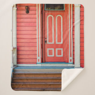 Traditional red painted wooden door and porchdoor, sherpa blanket