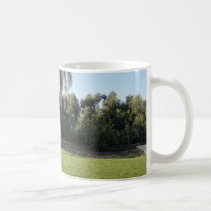 Tranquil Escape: Lush Lawn and Towering Trees Coffee Mug