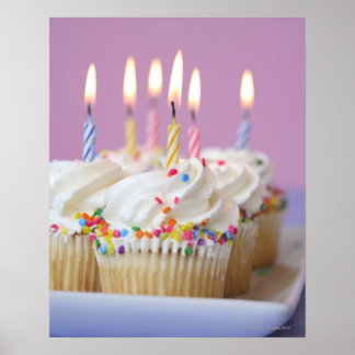 Tray of birthday cupcakes with candles poster