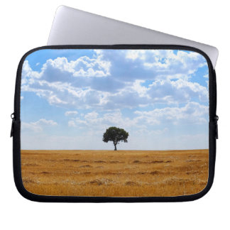 Tree in an harvested wheat field laptop sleeve