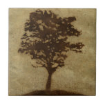 Tree Silhouette on Bronze Background Tile<br><div class="desc">A bronze background serves as the scene for this silhouette of a tree with branches swaying in the breeze. You almost feel as if you could rest your back against this tree,  sit on the ground and take a long nap.</div>
