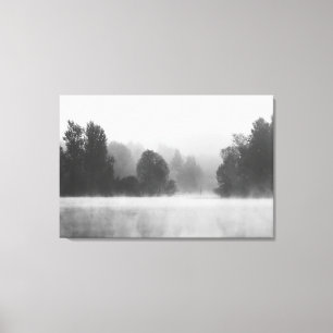 Trees disappearing in morning fog above the lake canvas print