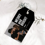 Trendy Merry & Bright Photo Christmas Gift Tags<br><div class="desc">Trendy holiday custom photo gift tags with a modern minimal typography quote "merry and bright" and your family name on a black background that can be changed to any colour.  A minimalist and contemporary design that is unique and will stand out this holiday season!</div>