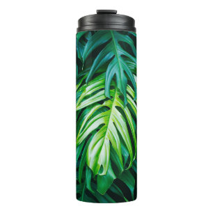 Tropical green leaves on dark background, nature s thermal tumbler