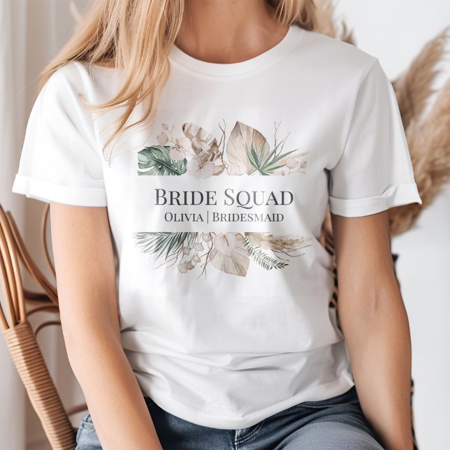 Tropical Orchid with Monstera Bride Squad Tshirt (A young blond woman wearing a Tropical Orchid with Monstera Bride Squad T-shirt.)