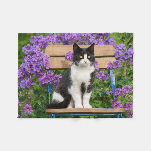 Tuxedo cat sitting on a garden chair with flowers fleece blanket (Front (Horizontal))