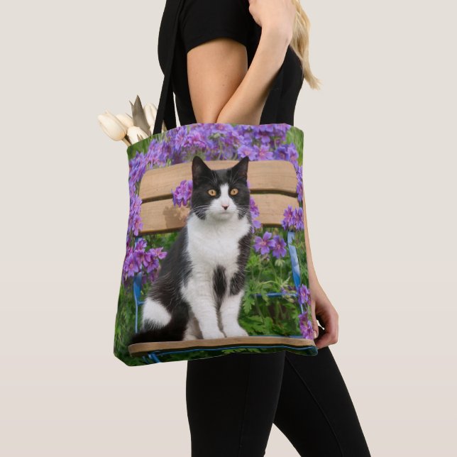 Tuxedo cat sitting on a garden chair with flowers tote bag (Close Up)