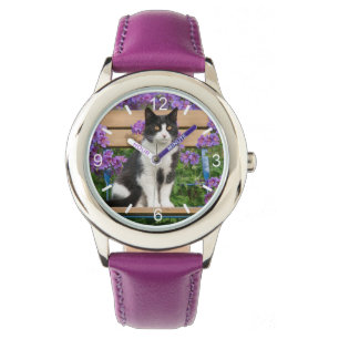 Tuxedo cat sitting on a garden chair with flowers watch