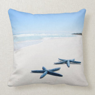 Two blue starfish at water's edge on tropical 2 cushion