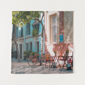 Two brown table outside tapestry