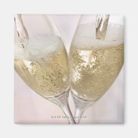 Two champagne flutes being filled with sparkling