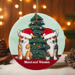 Two Corgi Tricolor Red White Santa Hat Christmas Ceramic Tree Decoration<br><div class="desc">This beautiful Pembroke Welsh Corgi dog ornament features two dogs wearing Santa Claus hats with an adorable head tilt. One tricolor pup and one red and white doggy sitting in front of a pretty Christmas tree decorated with colorful ornaments. Personalize your pet's names in lovely cursive under the wonderful drawing...</div>