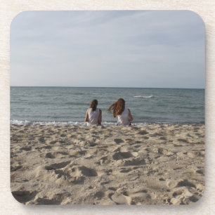 Two Girls on Sandy Beach: 2 Girls Face Windy Ocean Coaster
