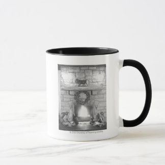 Two girls sitting by a fireplace at Christmas Mug