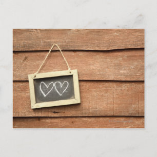 Two hearts drawn on small blackboard on garden postcard