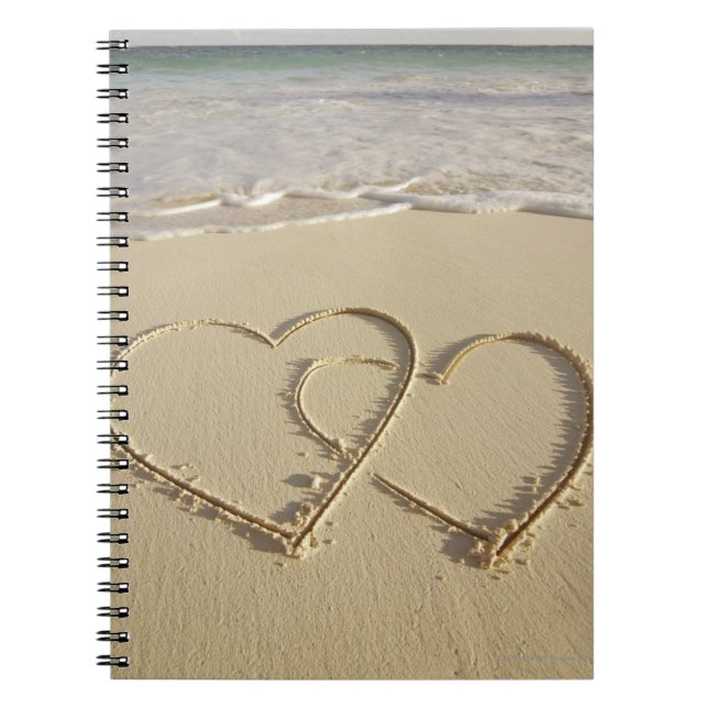 Two overlying hearts drawn on the beach with notebook (Front)