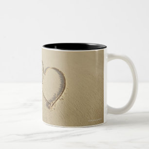 Two overlying hearts drawn on the beach with Two-Tone coffee mug