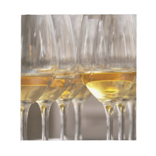 two rows of wine tasting glasses with lucious notepad