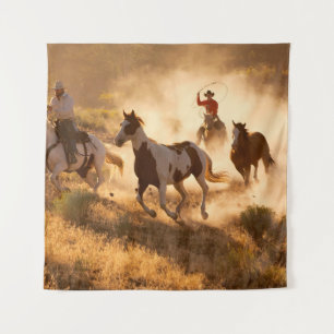 Two western cowboys riding horses, roping wild hor tapestry