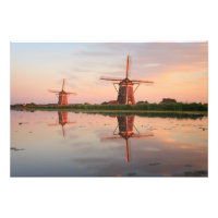 Two windmills with reflection at sunset