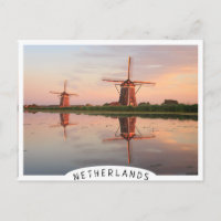 Two windmills with reflection at sunset