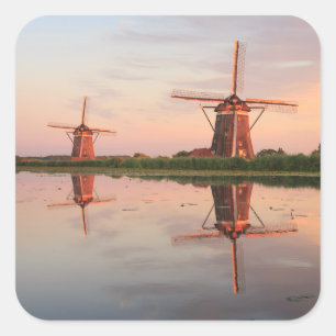 Two windmills with reflection at sunset square sticker