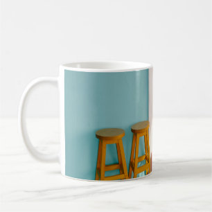 Two yellow wooden bar stools coffee mug