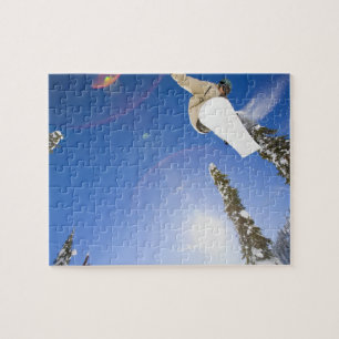 USA, Montana, Whitefish, Young man snowboarding Jigsaw Puzzle
