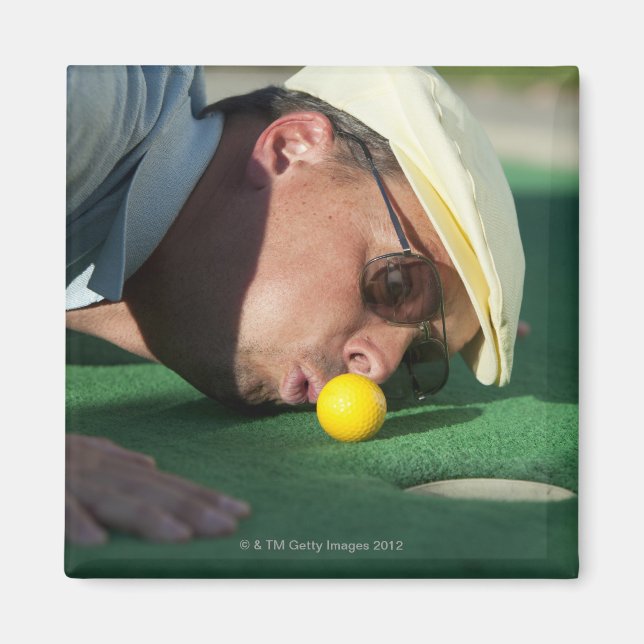 USA, Utah, Orem, Man blowing air to push golf Magnet (Front)