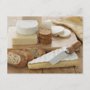 Various cheeses and bread on table postcard